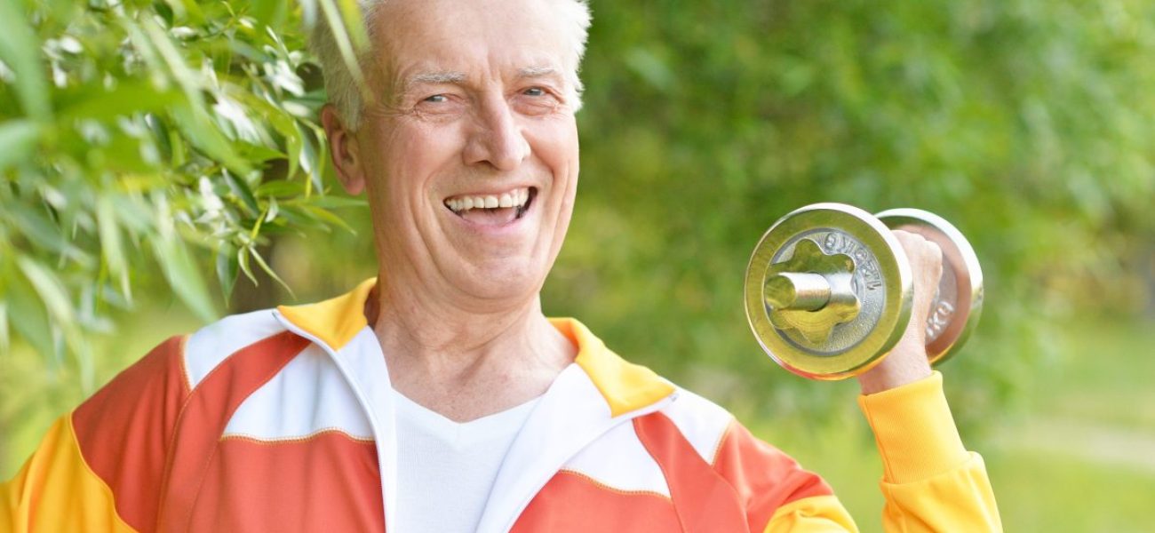 Elderly man exercising with dumbbell in  park