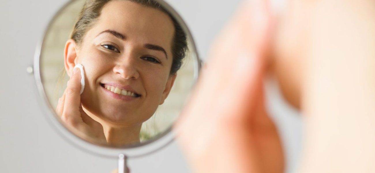 front-view-woman-cleaning-her-face-mirror