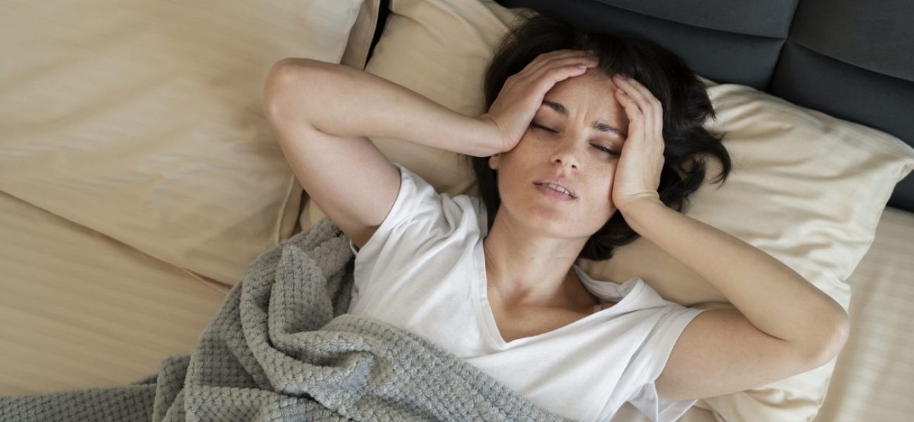 sick-woman-laying-bed-medium-shot