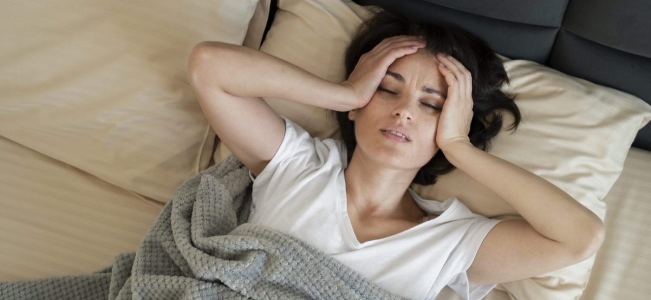 sick-woman-laying-bed-medium-shot